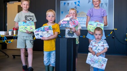Kinderen ontvangen cadeau na tekenwedstrijd tijdens jubileumviering HBV