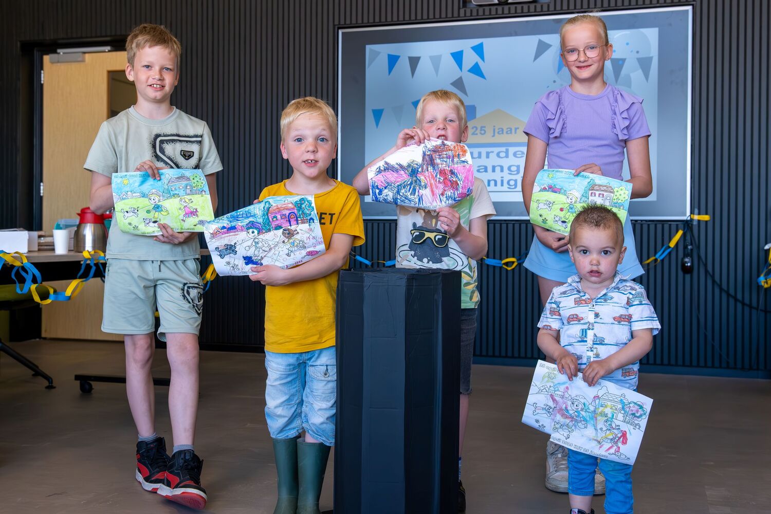 Kinderen ontvangen cadeau na tekenwedstrijd tijdens jubileumviering HBV